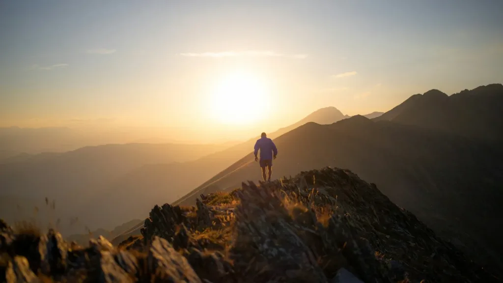 man-standing-on-mountain-sunset