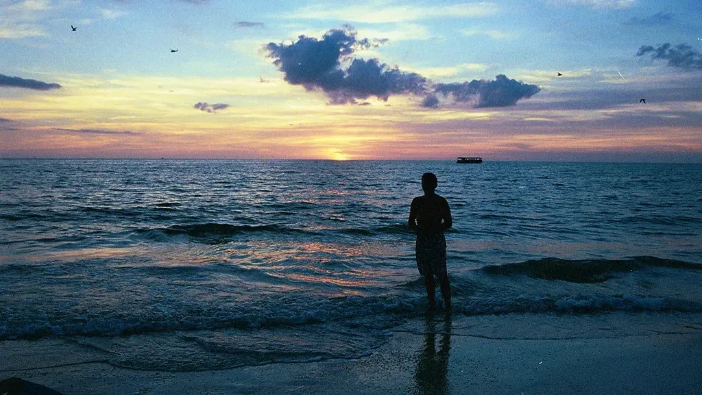 man-shore-beach-sunrise-sunset-water-ocean-waves-sky-silhouette