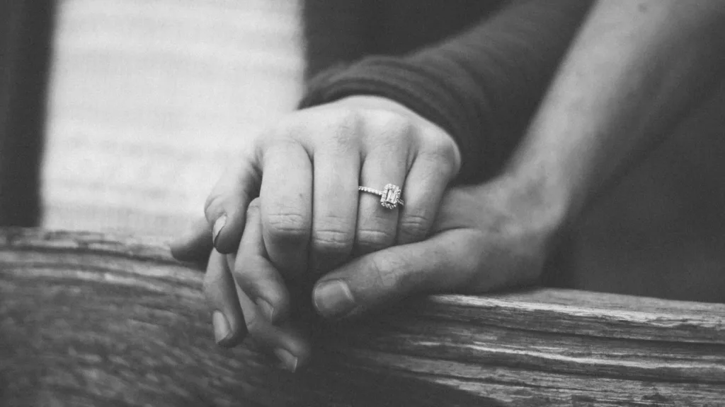a-couple-holding-hands-with-a-wedding-ring visible